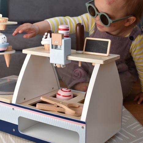 enfant qui jouet avec jeux en bois d'imitation cuisine