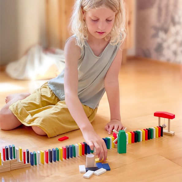 enfant joue avec domino en bois Montessori