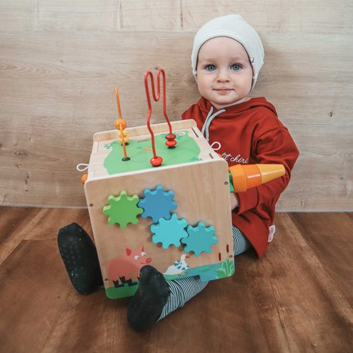 enfant qui joue avec un cube de motricité